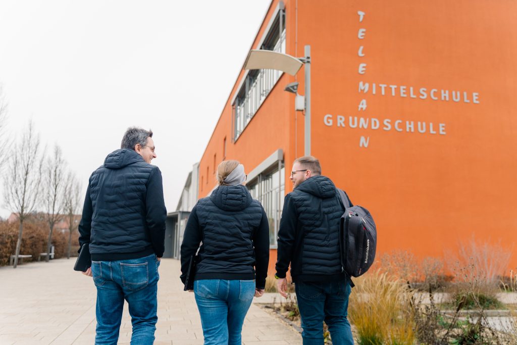 VALEO IT Mitarbeiter vor Schulgebäude – VALEO IT betreut schulische IT für Bildungseinrichtungen